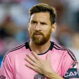 Piłkarz w różowej koszulce z opaską kapitana, z ręką na sercu. Plotki o tym, że messi nie żyje, są fałszywe.