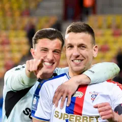 Dwóch piłkarzy Jagiellonii Białystok świętuje zwycięstwo nad Górnikiem Zabrze.