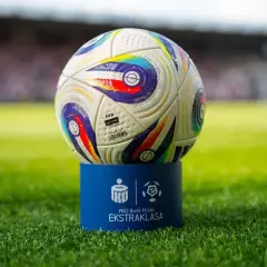Piłka PKO Bank Polski Ekstraklasa na niebieskim postumencie. Czas odmierza, ile kolejek do końca sezonu.