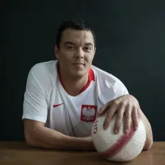 Dawid Janczyk w koszulce reprezentacji Polski z piłką w dłoni, gotowy do gry.