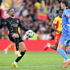 Piłkarz PSG, Kimpembe, w czarnej koszulce z logo Qatar Airways, prowadzi piłkę na boisku.