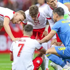 Piłkarze otaczają kolegę z drużyny, który doznał kontuzji. Widoczna jest koszulka z napisem "MILIK" i numerem 7.
