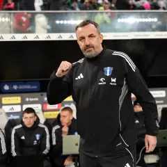 Trener Wisły Płock z zaciśniętą pięścią, symbolizującą determinację w walce o nowe transfery.