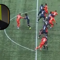 Arsene Wenger patrzy na boisko, gdzie piłkarze w czerwonych i granatowych strojach tworzą szpaler.