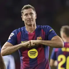 Robert Lewandowski w koszulce Barcelony, z gestem radości. Zastanawiasz się, ile zarabia Lewandowski na minutę?