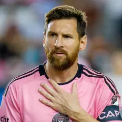 Piłkarz w różowej koszulce z opaską kapitana, z ręką na sercu. Plotki o tym, że messi nie żyje, są fałszywe.