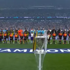 Piłkarze i dzieci stoją na murawie przed finałem Ligi Mistrzów, słychać hymn.