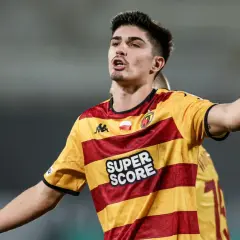 Piłkarz Korony Kielce w żółto-czerwonej koszulce z napisem "SUPER SCORE" gestykuluje podczas meczu z Jagiellonią Białystok.
