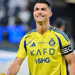 Uśmiechnięty Cristiano Ronaldo w żółtej koszulce Al Nassr. W jakim klubie gra Ronaldo? W Al Nassr!