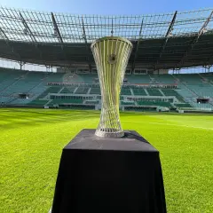 Błyszczący puchar Konfederacji UEFA na tle pustego stadionu.