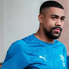Piłkarz Malcom w niebieskiej koszulce z logo Al-Hilal i Pumy, z tatuażem na szyi.