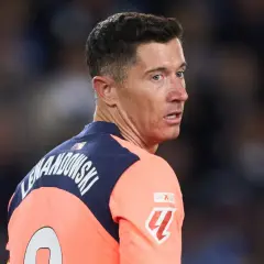 Robert Lewandowski w akcji, w pomarańczowej koszulce z numerem 9. Widać jego nazwisko na plecach.