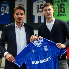 Dwaj mężczyźni prezentują niebieską koszulkę Lecha Poznań. To kolejny z transferów klubu.