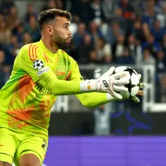 Bramkarz David Raya w jaskrawozielonym stroju łapie piłkę.