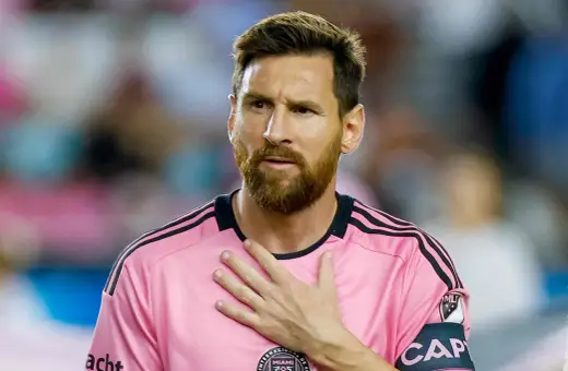 Piłkarz w różowej koszulce z opaską kapitana, z ręką na sercu. Plotki o tym, że messi nie żyje, są fałszywe.