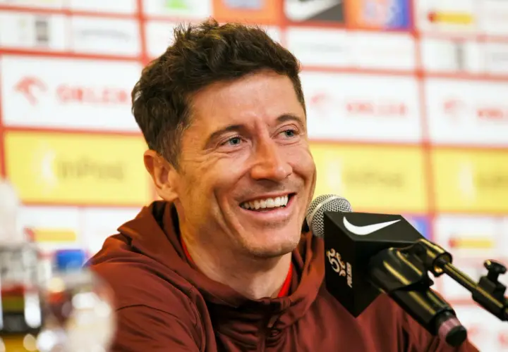 Uśmiechnięty Robert Lewandowski przy mikrofonie. Jego majątek to efekt ciężkiej pracy i talentu.