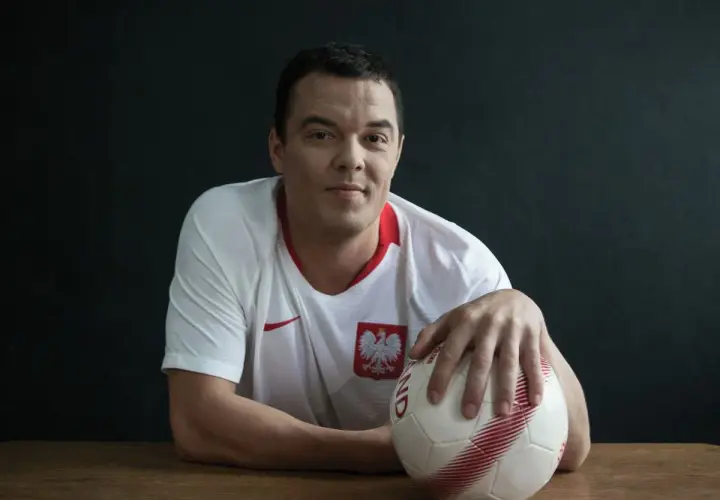 Dawid Janczyk w koszulce reprezentacji Polski z piłką w dłoni, gotowy do gry.