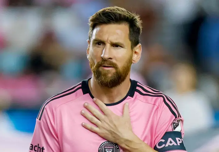 Piłkarz w różowej koszulce z opaską kapitana, z ręką na sercu. Plotki o tym, że messi nie żyje, są fałszywe.