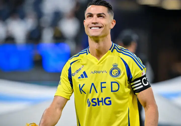 Uśmiechnięty Cristiano Ronaldo w żółtej koszulce Al Nassr. W jakim klubie gra Ronaldo? W Al Nassr!