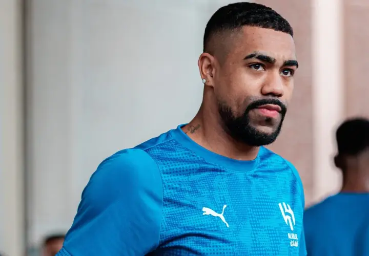 Piłkarz Malcom w niebieskiej koszulce z logo Al-Hilal i Pumy, z tatuażem na szyi.
