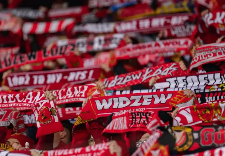 Tłum kibiców Widzewa Łódź z szalikami. Fani świętują, a na szalikach widnieją napisy "Widzew", "Łódź to my" i rok 1910. To symbol ich dumy i wsparcia dla klubu, który zawsze budzi emocje, zwłaszcza podczas ważnych widzew łódź transfery.