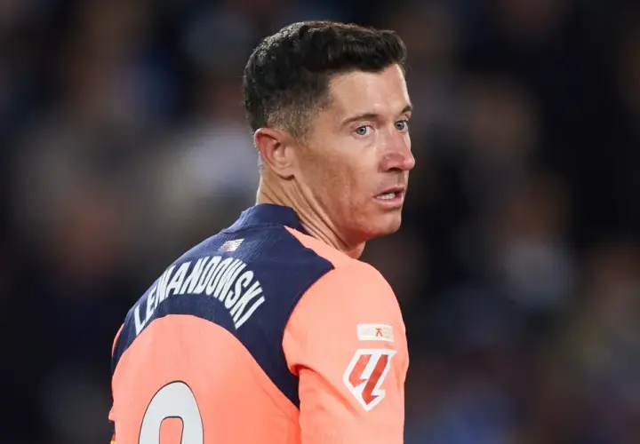Robert Lewandowski w akcji, w pomarańczowej koszulce z numerem 9. Widać jego nazwisko na plecach.