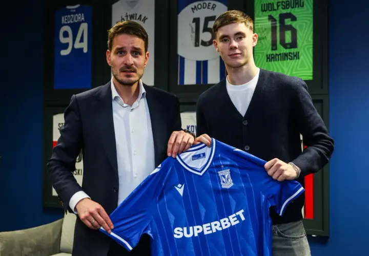 Dwaj mężczyźni prezentują niebieską koszulkę Lecha Poznań. To kolejny z transferów klubu.