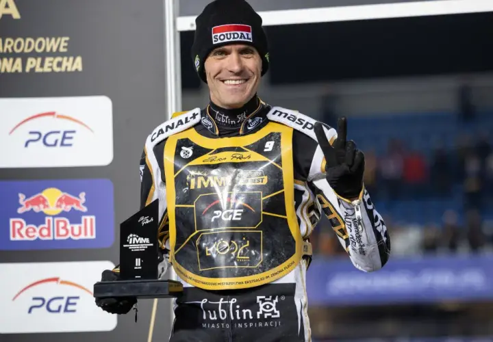Uśmiechnięty żużlowiec Motor Lublin z pucharem, symbolizuje udane transfery i zwycięstwa.