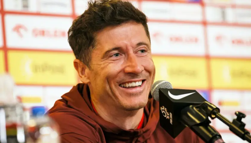 Uśmiechnięty Robert Lewandowski przy mikrofonie. Jego majątek to efekt ciężkiej pracy i talentu.