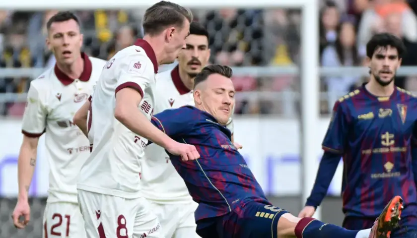 Piłkarze Pogoń Szczecin kontra Widzew Łódź. Zacięta walka o piłkę na boisku, emocje sięgają zenitu.