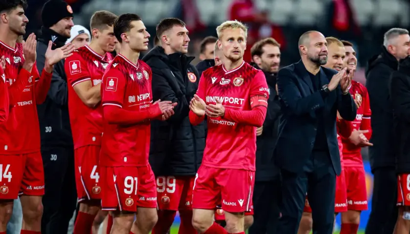 Piłkarze w czerwonych strojach, z numerami 14, 91, 99, 4, 6, klaszczą. Czy Widzew jest w Ekstraklasie?