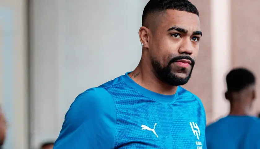 Piłkarz Malcom w niebieskiej koszulce z logo Al-Hilal i Pumy, z tatuażem na szyi.