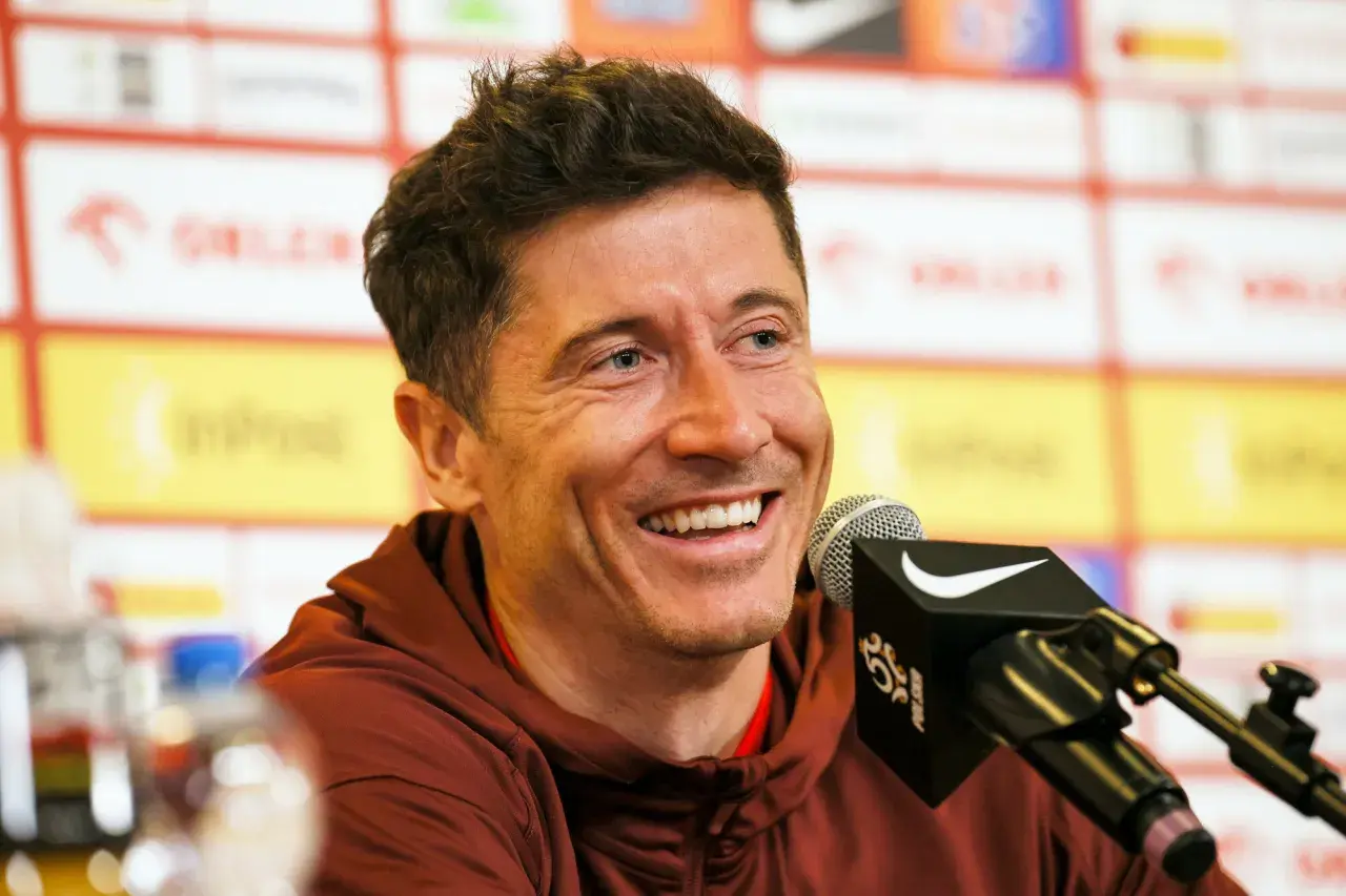 Uśmiechnięty Robert Lewandowski przy mikrofonie. Jego majątek to efekt ciężkiej pracy i talentu.
