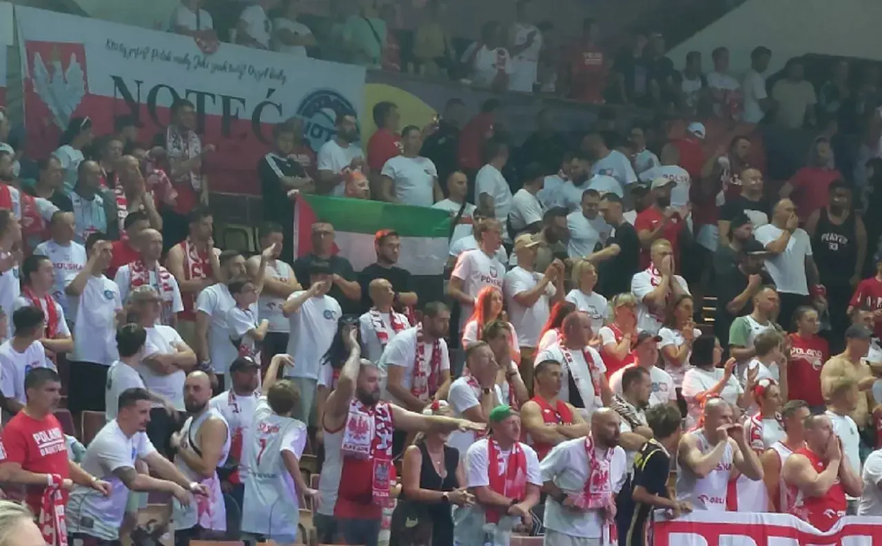 Tłum kibiców w biało-czerwonych barwach, z flagami i szalikami. Widać transparent z napisem "NOTEĆ". Atmosfera przypomina mecz, gdzie Polska rywalizuje z Izraelem.
