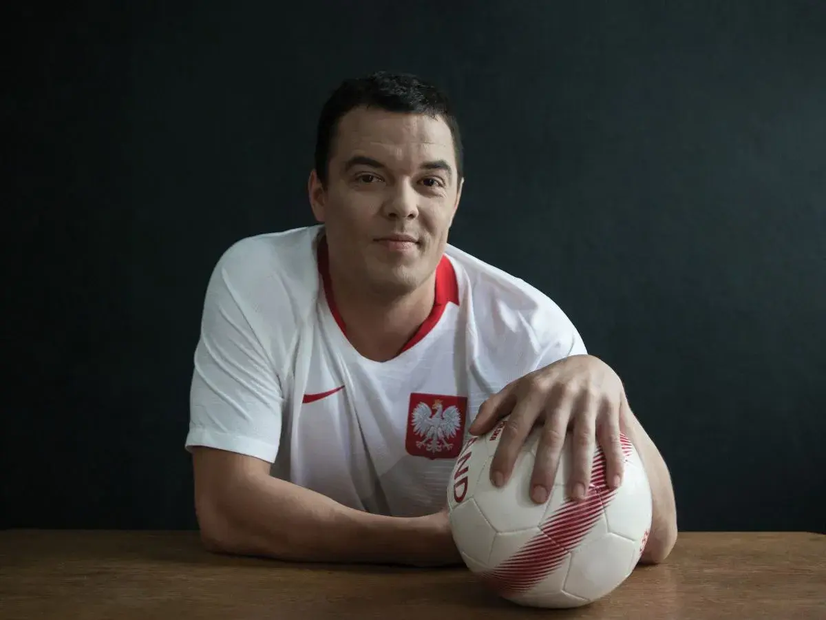 Dawid Janczyk w koszulce reprezentacji Polski z piłką w dłoni, gotowy do gry.