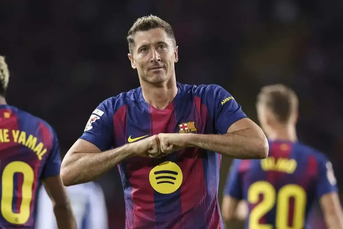 Robert Lewandowski w koszulce Barcelony, z gestem radości. Zastanawiasz się, ile zarabia Lewandowski na minutę?