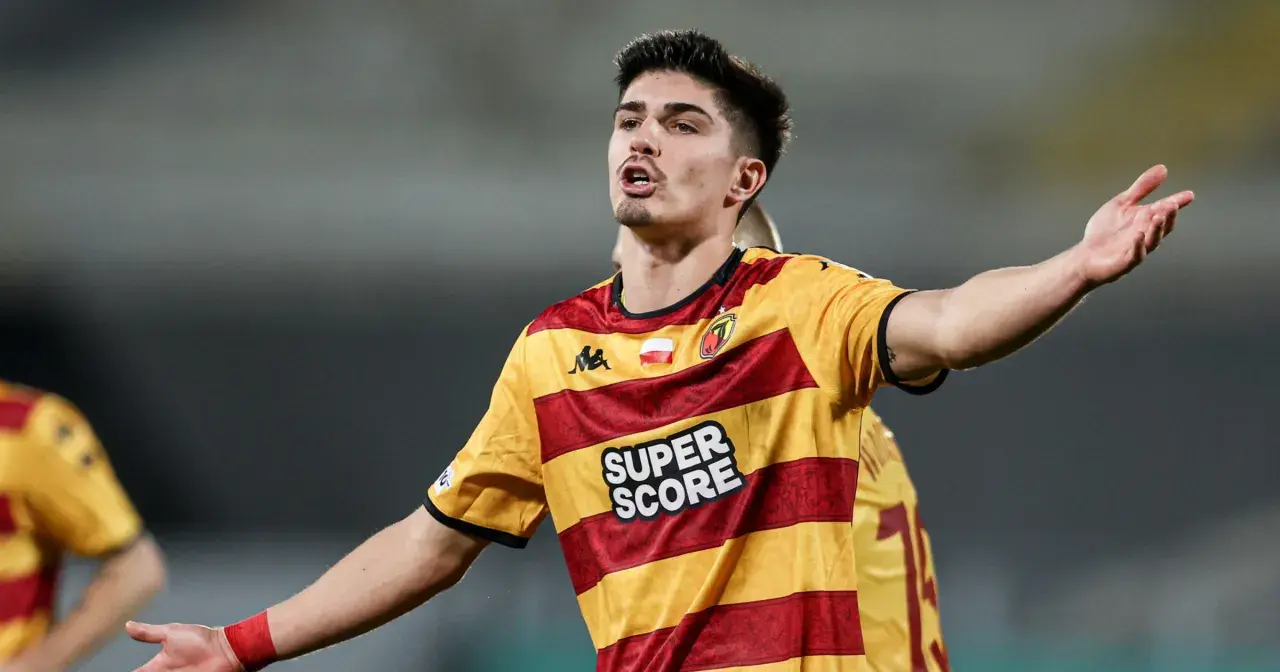 Piłkarz Korony Kielce w żółto-czerwonej koszulce z napisem "SUPER SCORE" gestykuluje podczas meczu z Jagiellonią Białystok.