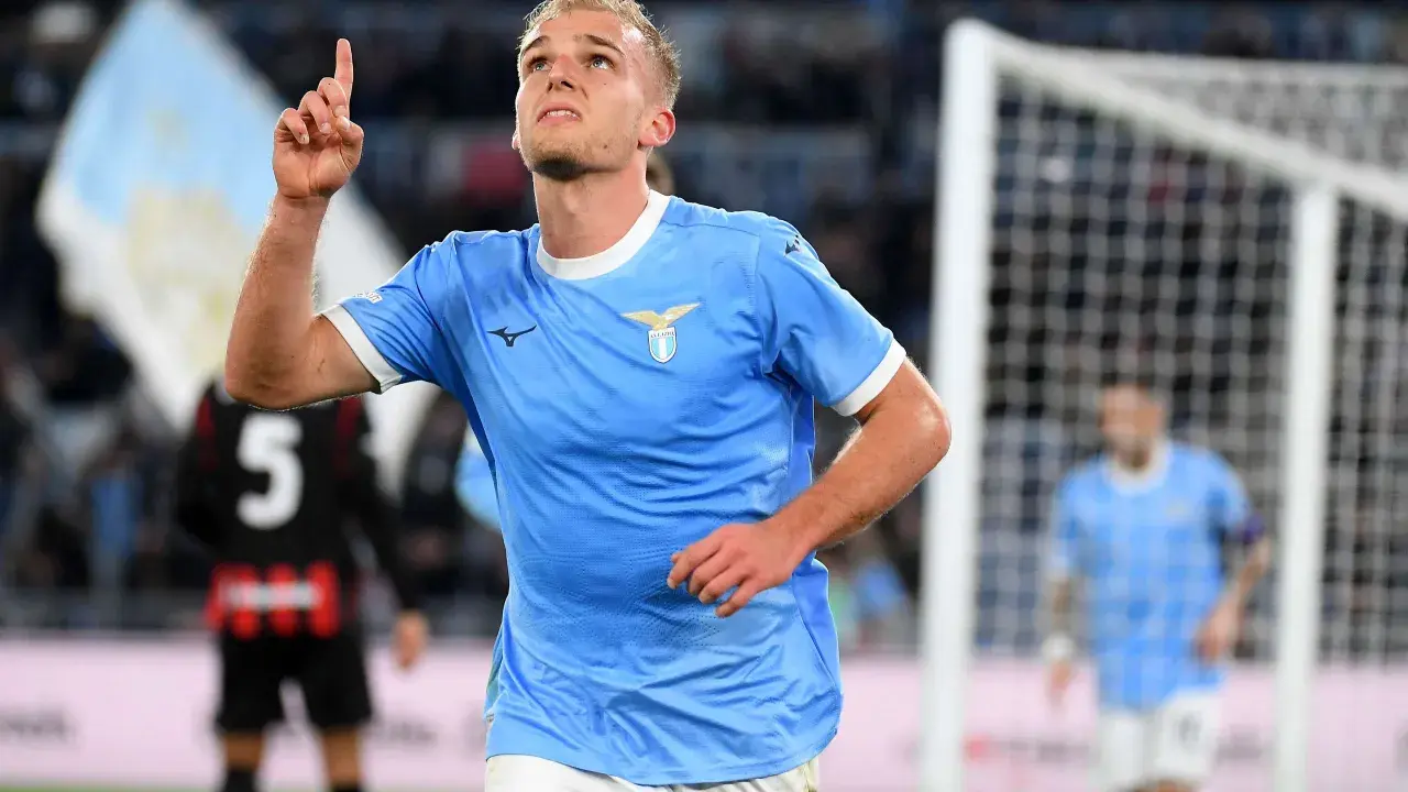 Piłkarz Lazio w błękitnej koszulce z uniesionym palcem, radośnie świętuje bramkę w meczu z A.C. Milan.