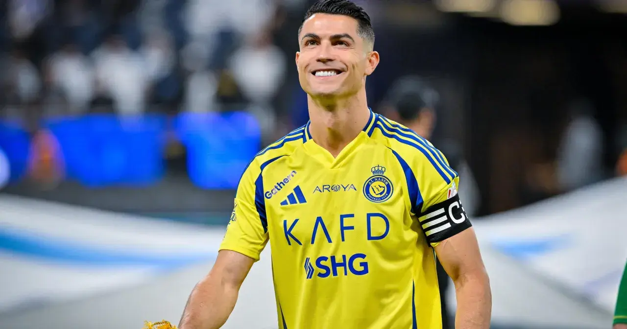 Uśmiechnięty Cristiano Ronaldo w żółtej koszulce Al Nassr. W jakim klubie gra Ronaldo? W Al Nassr!