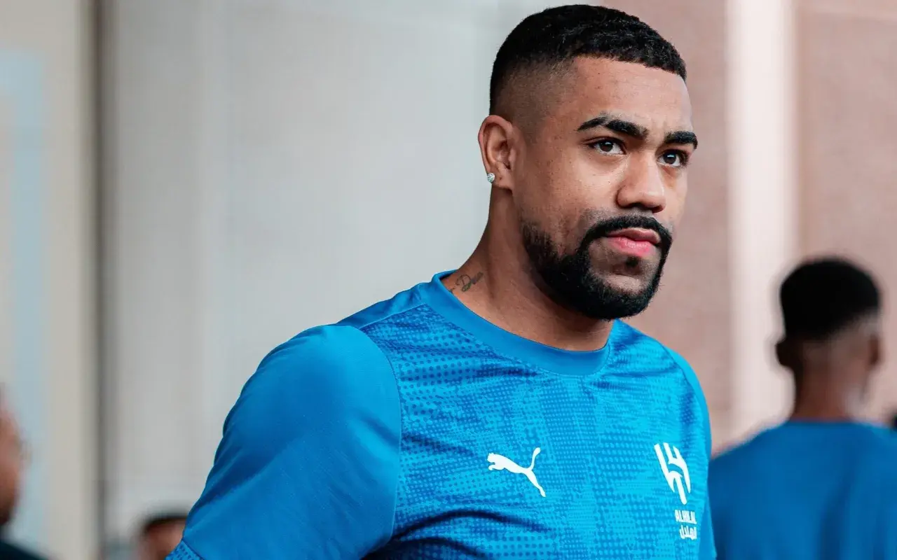 Piłkarz Malcom w niebieskiej koszulce z logo Al-Hilal i Pumy, z tatuażem na szyi.