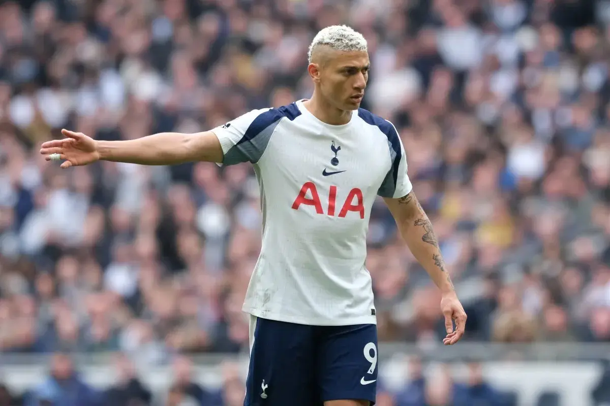 Piłkarz Tottenhamu z blond włosami w białej koszulce z logo AIA na tle trybun.