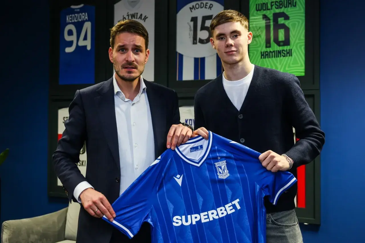 Dwaj mężczyźni prezentują niebieską koszulkę Lecha Poznań. To kolejny z transferów klubu.