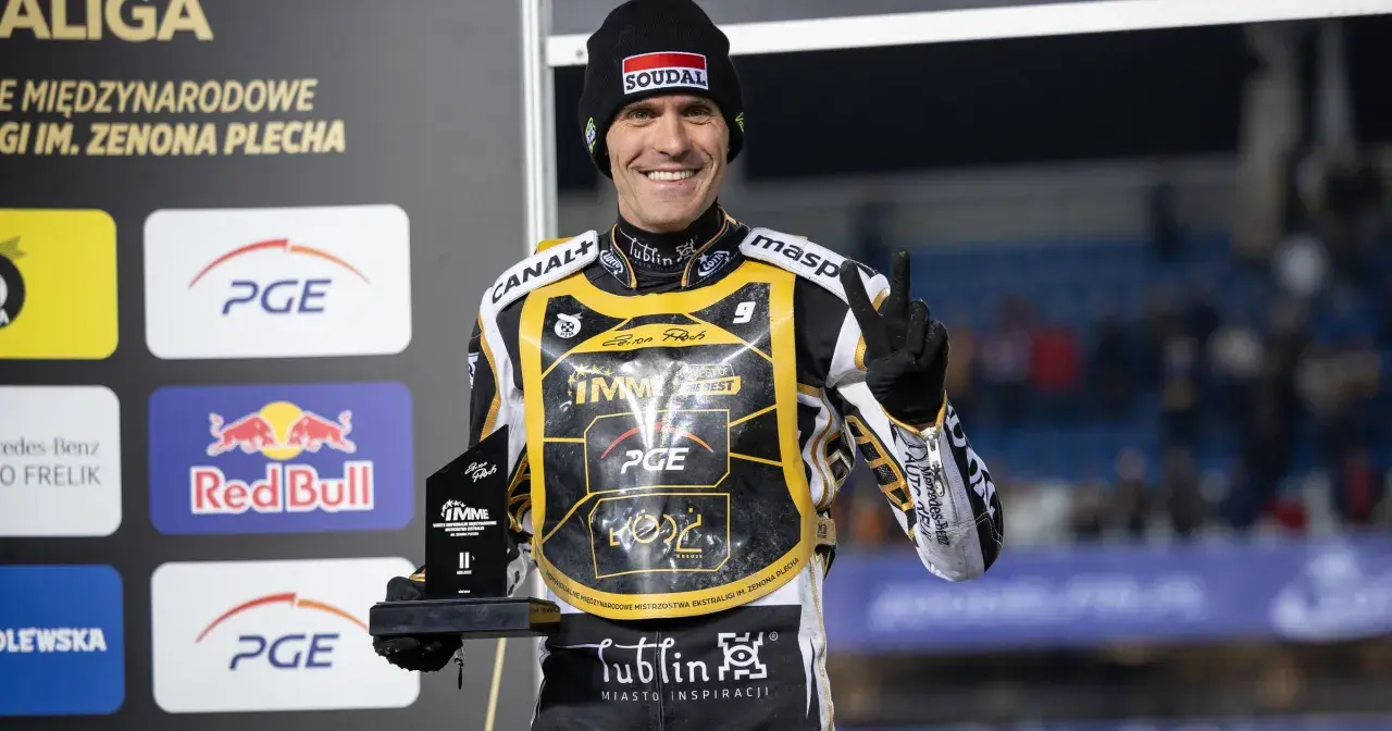 Uśmiechnięty żużlowiec Motor Lublin z pucharem, symbolizuje udane transfery i zwycięstwa.