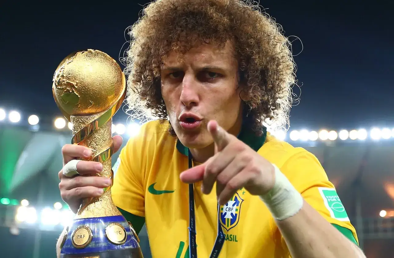 Piłkarz z Brazylii, z charakterystyczną fryzurą, trzyma złoty puchar. Wskazuje palcem, świętując zwycięstwo w Pucharze Konfederacji FIFA.