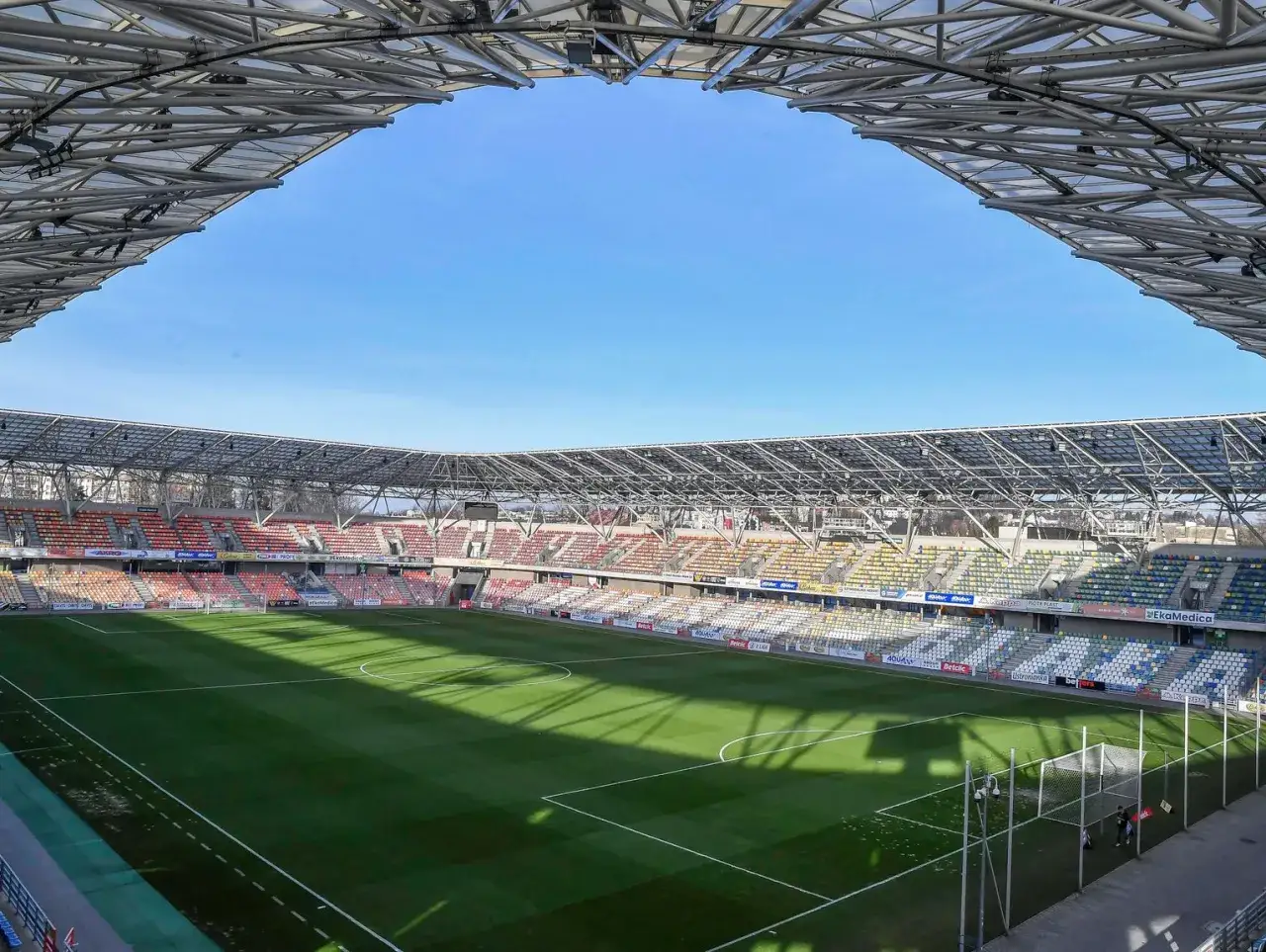 Pusta trybuna stadionu piłkarskiego, gotowa na emocje baraży o ekstraklasę.