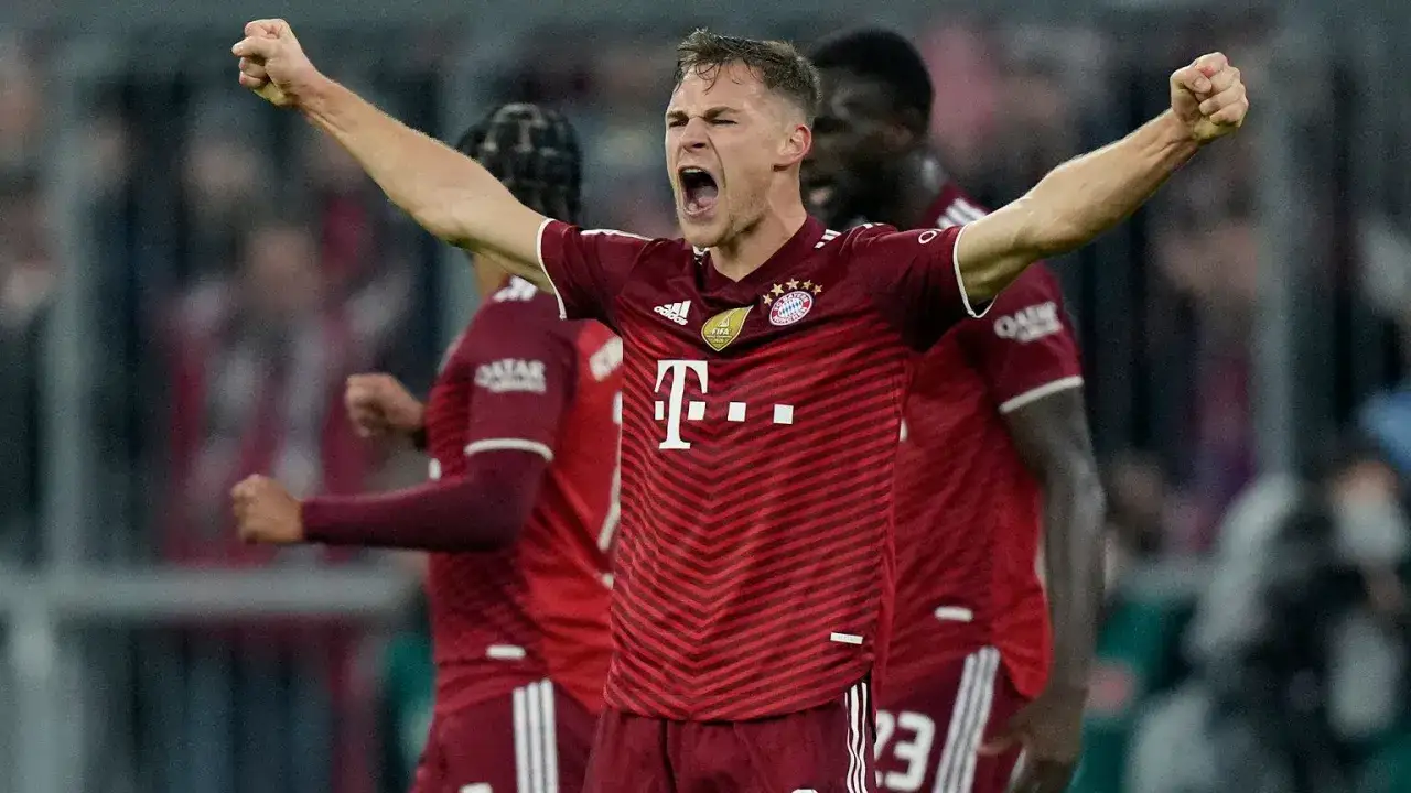 Joshua Kimmich świętuje zdobycie bramki, krzycząc z radości i unosząc ręce w geście triumfu.