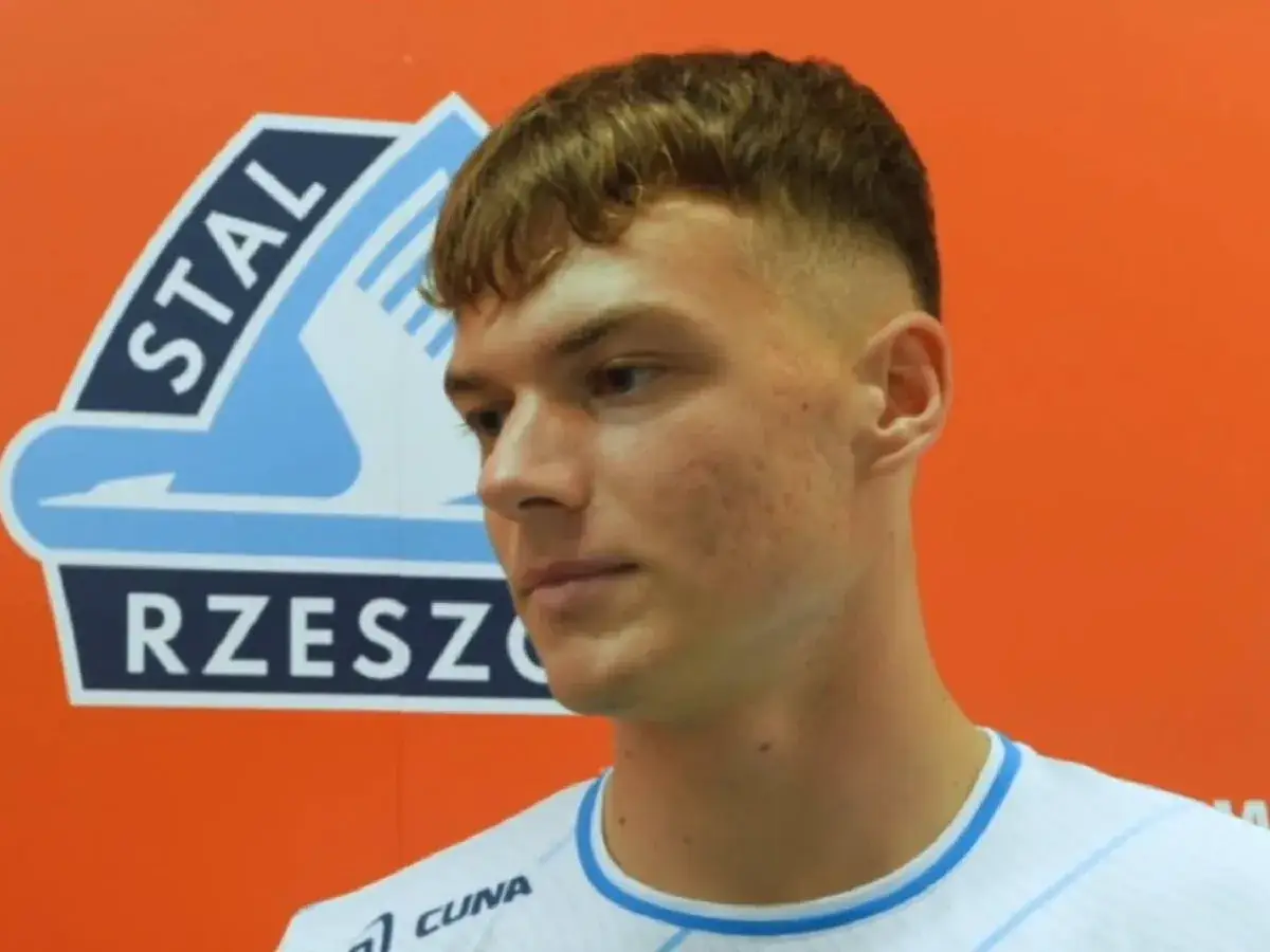 Młody piłkarz Stali Rzeszów, potencjalny cel ekstraklasa transfery, na tle klubowego logo.