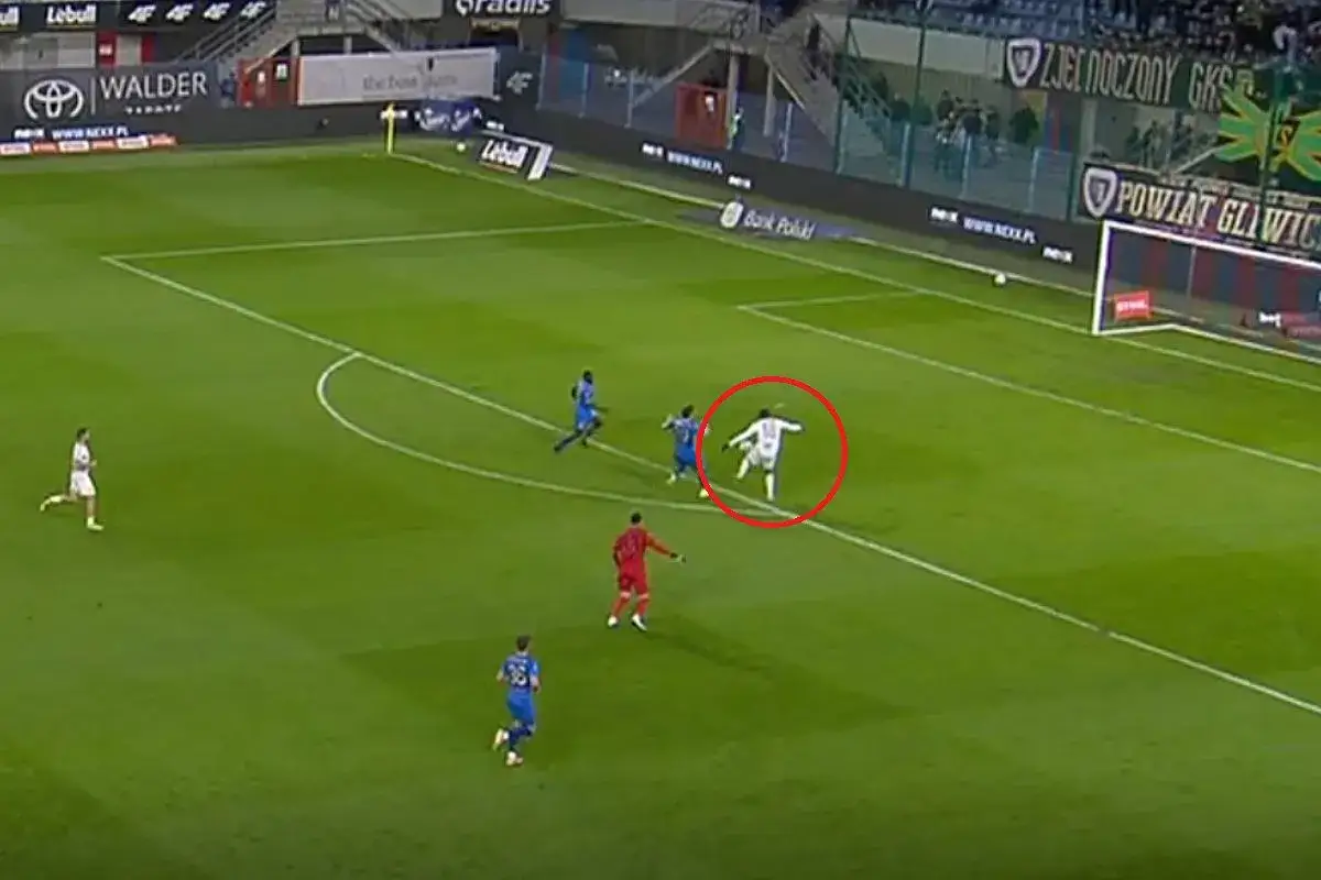Piast Gliwice – Pogoń Szczecin. Piłkarz w białej koszulce w czerwonym okręgu biegnie z piłką w kierunku bramki.