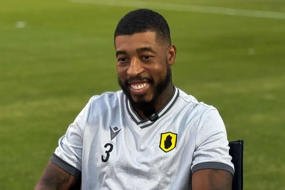 Uśmiechnięty piłkarz Kimpembe w jasnej koszulce z numerem 3 i herbem klubu.